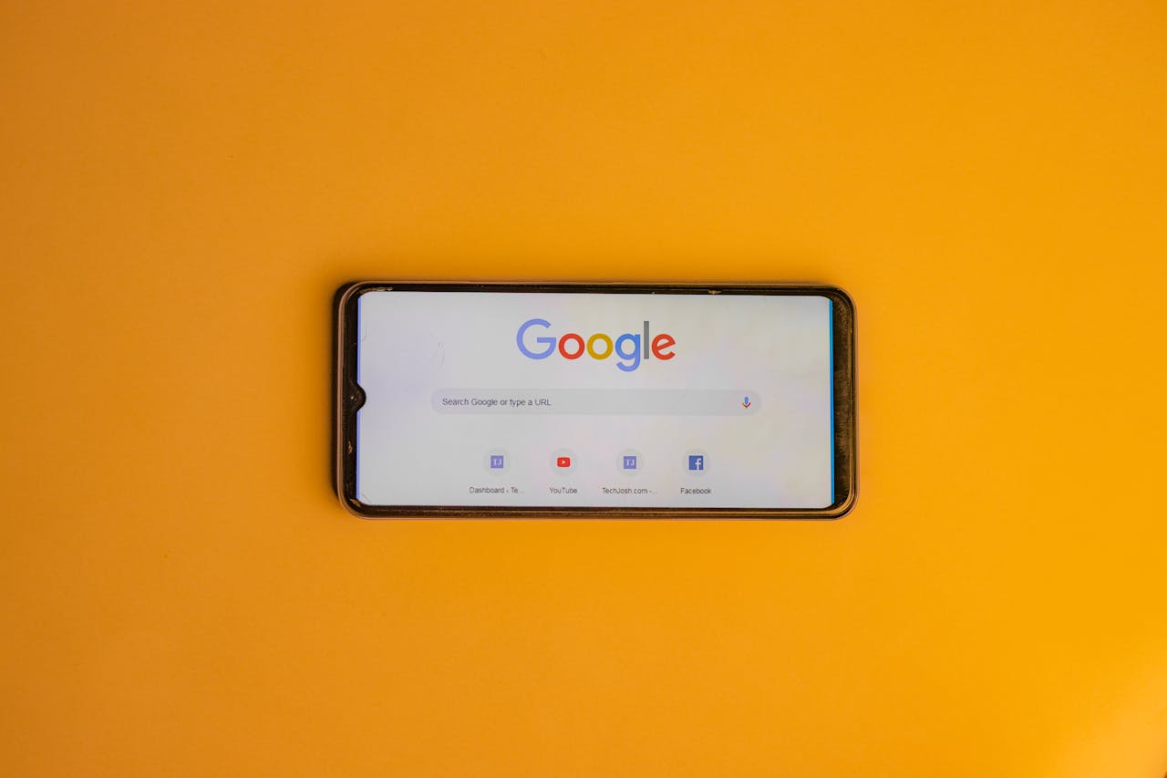 services-03 Smartphone displaying Google search page on a vibrant yellow background.